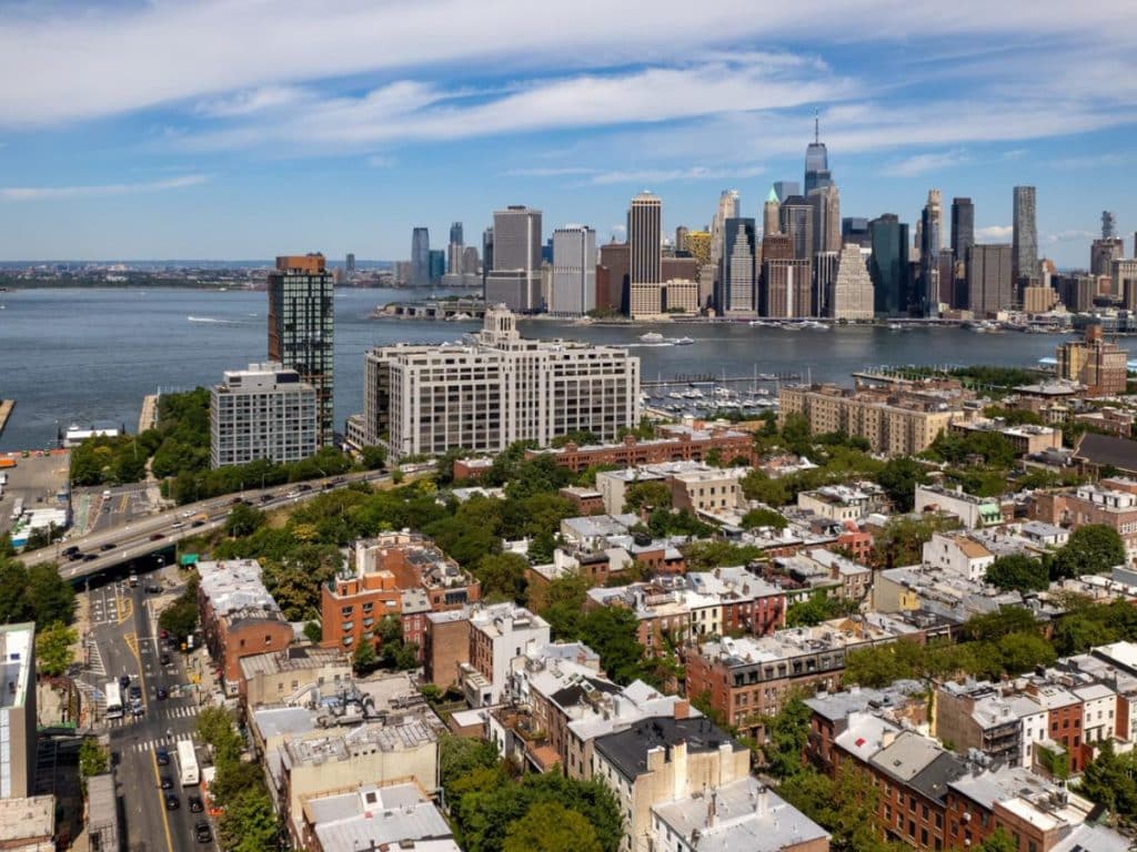 An aerial view of Brooklyn, NY on a beautiful day with blue skies and white clouds