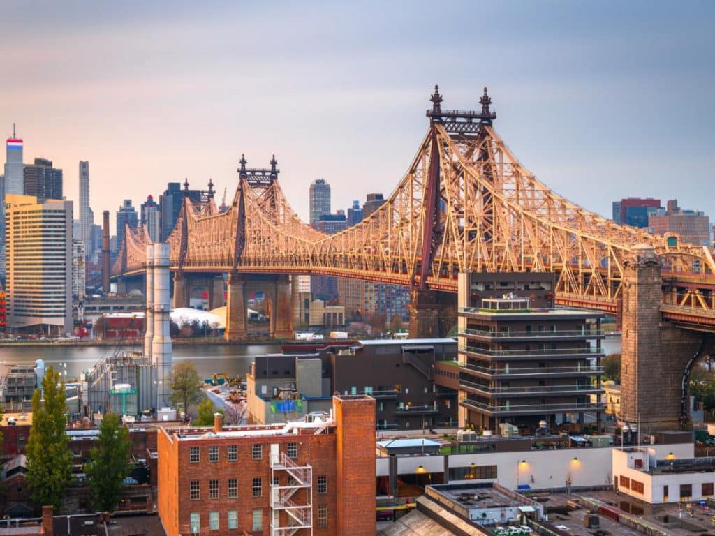 Queens, New York, USA view with the Queensboro Bridge towards Manhattan at dusk